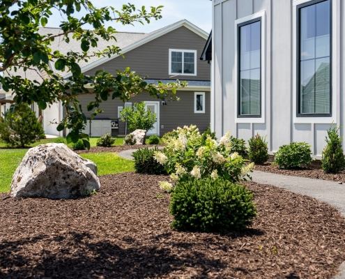 Shreckhise_McGraw_After-15 A home's sidewalk entrance with landscaping and boulder features.