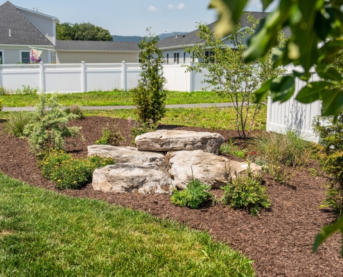 Shreckhise_McGraw_After-5 a plant bed with a boulder and plants.